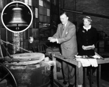 A black and white photo of a white man in a suit and a white woman in a dark dress and hat ringing a large metal bell. The bell is circled in white.