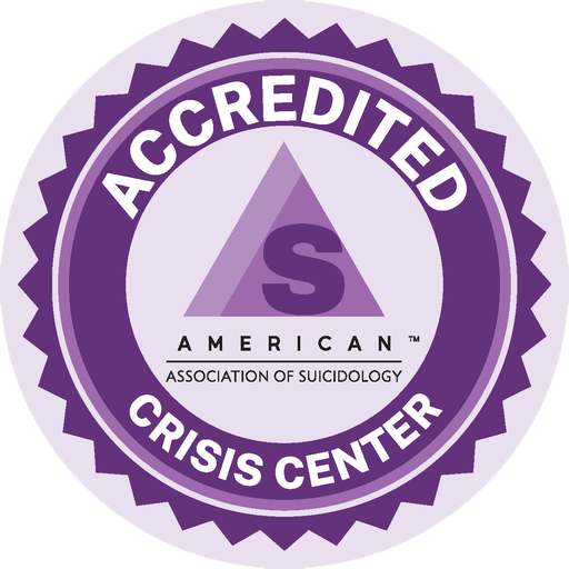 A business seal, a lavender circle has a darker purple circle over it. In white the words Accredited Crisis Center appear around another lavender circle. In the center are two layered purple triangles with the letter S and the words American Association of Suicidology.