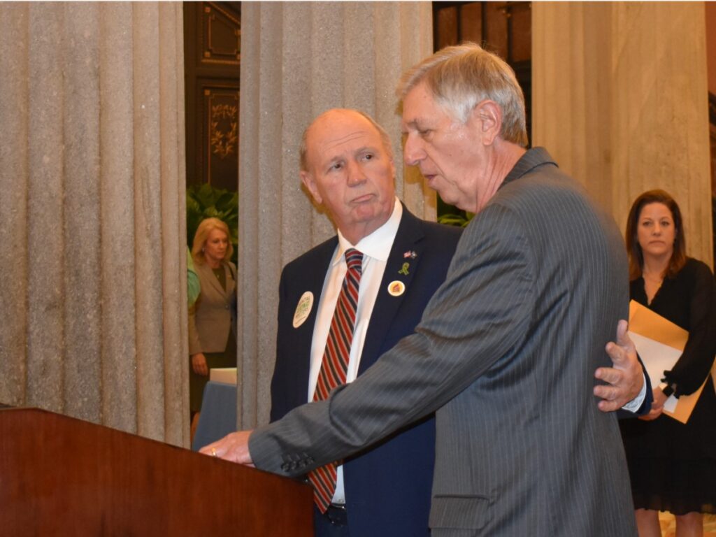 Senate Member Thomas Alexander stands with Bill Lindsey, Executive Director for NAMI SC, at a podium.