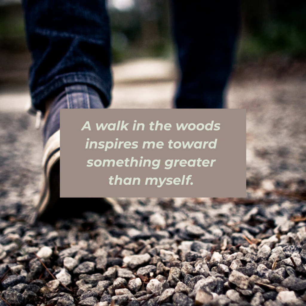 A photo of a persons feet walking on a gravel path with the words A walk in the words inspires me toward something greater than myself.