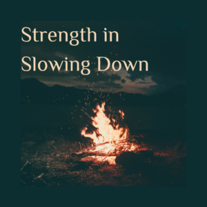 A camp fire at night with the words Strength in Slowing Down